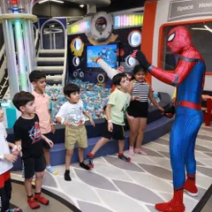 Watch your child's face light up when their favorite hero joins the party. Here, Spiderman interacts with a group of excited kids right in front of our space-themed play structure.