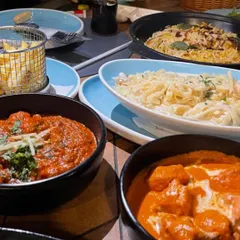For those who love variety, I create family-style feasts with a mix of cuisines. This table features bowls of classic Indian curries like butter chicken alongside creamy pasta dishes, catering to every taste.