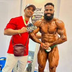 This is the moment a dream comes true. Here I am with my athlete, Bantu Rathore, after he won the Mr. Amateur Olympia title. I treat my clients' dreams as my own, and this is the result of that dedication.