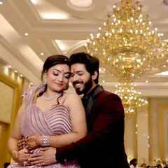A romantic shot of the engaged couple. Her makeup features a soft, shimmery eye and a subtle lip, complementing her lilac gown, while his grooming is natural and sharp.