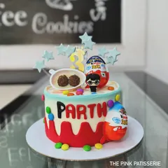 A fun and colorful cake topped with Kinder Joy eggs and a Harry Potter figure. It's a delightful mix of popular treats and characters for a child's birthday.
