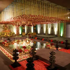An overview of the temple we built inside the banquet hall. The design features a central water body, amphitheater style seating for guests, and a magnificent floral ceiling, all framed by intricately carved pillars.