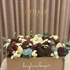 Why gift an ordinary bouquet when you can give a "berrylicious" one? This edible masterpiece is bursting with fresh strawberries dipped in white and dark chocolate, nestled among delicate flowers.
