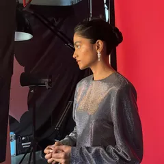 A candid shot of the model on set, just before the camera rolls. These in-between moments often have a beautiful, natural quality.
