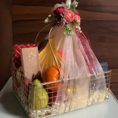 A beautiful fruit and sweets basket I created for Ganesh Chaturthi, elegantly wrapped in net with a floral arrangement on top.