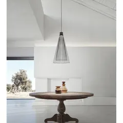 The Ikonika collection also includes this suspension lamp, seen here in a minimalist indoor dining space. Its wireframe structure is light and airy, allowing it to define a space without overwhelming it.