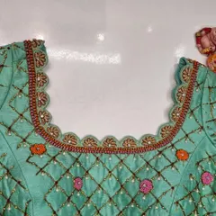 The front neckline of the mint green blouse, showcasing the delicate scalloped border and the continuation of the embroidered lattice pattern.