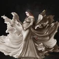 A breathtaking portrait of a mom-to-be in a shimmering gold gown with fabric that flows like wings. This is a perfect example of the fine-art, dramatic style I can create in the studio.