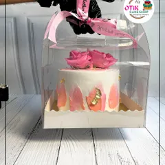 An elegant Mother's Day cake with pink rose decorations, presented in a clear carrying case with a "Happy Mother's Day" ribbon. It's a gift that's as beautiful as it is delicious.