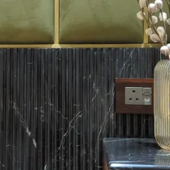 A close-up on the interplay of textures. Here, we combined fluted black marble, olive green velvet panels, and brass inlays to create a rich and tactile surface.