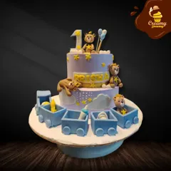 All aboard the birthday express! This two-tier cake for a first birthday features a cute train filled with teddy bears and baby items, creating a playful and adorable theme for the celebration.