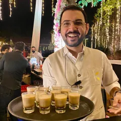 Service with a smile. Our founder is hands-on at events, here serving a tray of our signature chai shots and ensuring every guest feels welcomed and looked after.