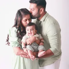 Pure bliss. The smiles on their faces say it all as they cuddle their little one. This is a classic family portrait that radiates warmth and happiness.