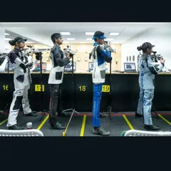 A line of our youth shooters in full gear, demonstrating the discipline and posture required for competitive air rifle shooting. Each athlete is focused on their individual target.