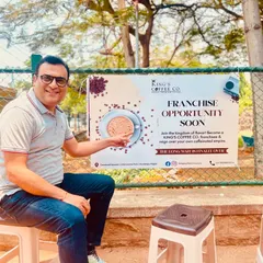 Here, our consultant points to a franchise opportunity banner for King's Coffee Co. in Mysore. This brand has grown from a small kiosk to a full-fledged cafe, and we are now helping them expand through franchising.