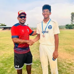 A player receiving an award on our well-maintained ground, with the nets visible in the background.