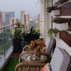 This apartment balcony was designed for relaxation with comfortable wicker chairs and a view of the city. We used a mix of artificial grass and planters to create a garden feel, complemented by a wooden accent wall with box planters.