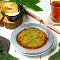 My authentic Kunafa, served hot and fresh. It has a crispy, golden exterior and a warm, cheesy interior, topped with a generous amount of crushed pistachios. It's a must try when you visit my store.