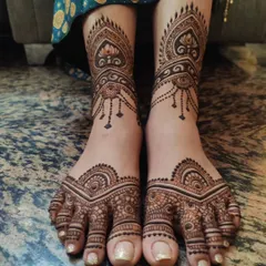 A beautifully symmetric and intricate design for the feet. This pattern features delicate hanging elements around the ankle and detailed work covering the top of the foot, ensuring you look festive from head to toe.