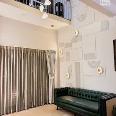 For this duplex living room, I used a bold, green leather Chesterfield sofa to anchor the space with color and classic style. The high ceilings are accentuated by custom-fitted curtains, creating a sense of grandeur and elegance.