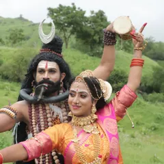 The dynamic energy of Shiva and Parvati. This shot showcases the detailed makeup and hairstyling, including the 'jata' (matted locks) of Lord Shiva and the divine glow of Goddess Parvati.