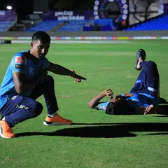 A candid moment on the field after a training session. Coaching is about pushing athletes but also knowing when to share a laugh and build morale.