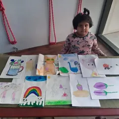 This is Nataniya, one of our 6-year-old students, with a selection of her work. Even at a young age, she has explored everything from rainbows and cartoons to still life drawings of vegetables.