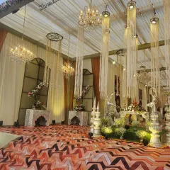 A symphony of light and texture, this setup combines grand crystal chandeliers with cascading string-light installations for a dramatic and glamorous effect.
