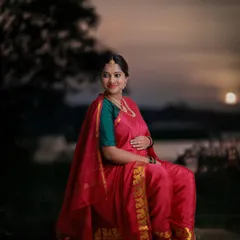 Inspired by the classic paintings of Ravi Varma, this outdoor sunset shot captures a mom-to-be in a traditional red saree, creating a timeless and artistic portrait.