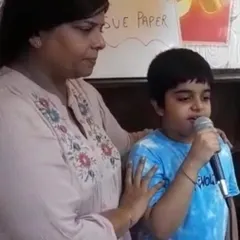 This student is practicing his delivery, holding the microphone with growing confidence. My goal is to make speaking in front of others feel as natural as a conversation with a friend.