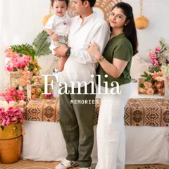 A standing family portrait that exudes warmth. The coordinated green and white outfits pop against the floral and rattan decor, creating a fresh and modern family photo.
