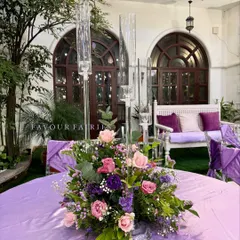 A beautiful floral centerpiece for the enchanted garden party. We used a mix of pink and purple flowers with tall glass candle holders to add elegance to the tables.