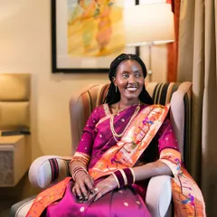 A happy, relaxed portrait of a bride in a beautiful magenta and orange saree.
