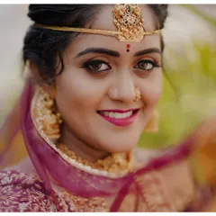 A bride's smile holds all the light of her special day. This portrait captures the happiness and anticipation of a South Indian bride, highlighting the intricate details of her jewelry and the genuine glow of her excitement.
