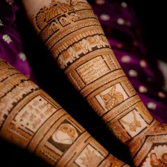 This design incorporates sacred Sanskrit shlokas written clearly on the forearms, surrounded by traditional motifs like elephants and kalash, adding a spiritual dimension to the bridal henna.
