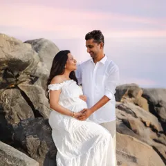 A quiet, loving gaze between partners during a sunset beach shoot. Couple portraits are a beautiful way to celebrate the partnership and teamwork that is at the heart of your growing family.