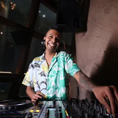 A smile is the best way to connect with the crowd. A candid shot of me enjoying the moment behind the decks in a colorful floral shirt.