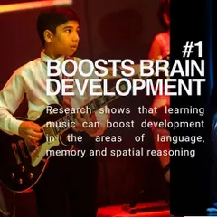 The number one benefit: learning music boosts brain development. This image shows a young student playing the guitar on stage, illustrating how research connects music practice with improved language, memory, and spatial reasoning skills.