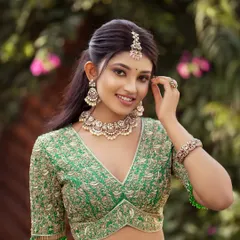 The smile says it all. This close-up showcases the beautiful fit and flattering V-neckline of the embroidered blouse, paired with delicate pearl jewelry to complement the green half saree.
