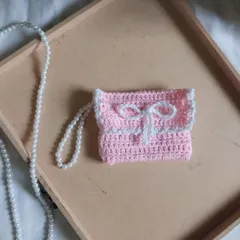 My chic and classy pink bow wallet, shown here with its delicate pearl strap. It's a small accessory that makes a big statement, perfect for gifting or treating yourself.