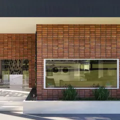 The facade of a marketing office designed to be a future clubhouse. I chose terracotta cladding for a timeless look that will develop a natural patina over time. A large window frames the view of the landscape, bringing the outdoors in and connecting the building to its site.