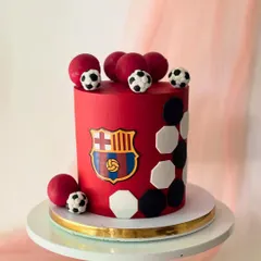 This bold red cake is for a FC Barcelona supporter. It's decorated with the club's iconic crest and a pattern of footballs.