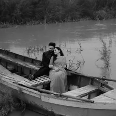A timeless black and white portrait on a rustic boat. This shot from Tulsi and Mohit's pre-wedding session evokes a sense of classic, old-world romance.