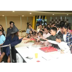 An instructor, dressed as a science wizard, engages a crowd of eager children. They are mesmerized by the experiments and can't wait to get their hands on the magic of science.