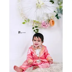 A charming solo portrait of a baby boy dressed in a dapper pink suit. We also capture individual shots of your little one during family sessions to highlight their budding personality.
