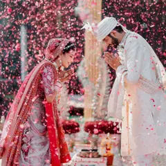 The couple exchanges a respectful 'Namaste' amidst a shower of petals, a beautiful moment of mutual reverence. We focus on capturing the cultural significance and emotion of each ritual.