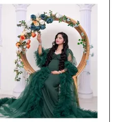 A beautiful solo portrait featuring one of our green tulle gowns. The mom-to-be is seated on a floral-adorned circular prop, creating a look that is both elegant and whimsical.