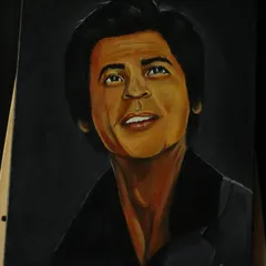 The full view of my SRK portrait on an easel, showing the warm tones and detailed work that went into capturing his likeness.