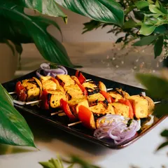 Another angle of the Saffron Paneer Skewers, showing the vibrant colors of the paneer, tomatoes, and onions. A visually stunning and delicious vegetarian option.