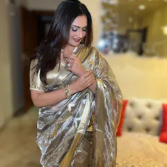 Saree, smile, and a whole lot of sass. This look features a classic bold lip and defined eyes, creating a timeless and elegant style that perfectly complements the metallic gold saree.